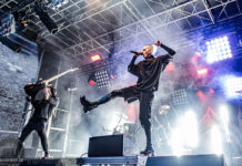 Castle Rock Festival 2026: Der letzte Vorhang auf Schloss Broich Vocalist onstage mid-leap with microphone, guitarist behind on left, dramatic stage lights and smoke surround a rock concert.