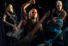 Klaas Helmecke und Pi Stoffers verlassen Lord Of The Lost Four metal musicians onstage during a high-energy performance; center bassist raises a fist while two guitarists play intensely under colorful stage lights.|center musician with long blond hair raises fist while playing bass, flanked by two guitarists, all in black stage outfits