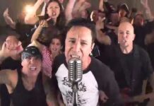 Lou Koller (Sick Of It All) ist gestorben Lead singer at a vintage microphone with an animated crowd cheering behind him in a band setting.