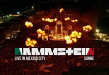 Rammstein veröffentlichen „Sonne (Live in Mexico City)“ Overhead view of a nighttime stadium concert with intense flames bursting from the stage and a packed crowd.