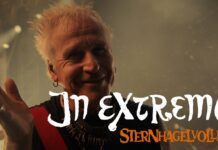 In Extremo: Neues Video „Sternhagelvoller“ vereint die Mittelalter-Rock-Szene Smiling male singer on stage with spiky blonde hair; white handwritten text 'In Extremo' and orange text 'Sternhagelvoller' overlay across the image.